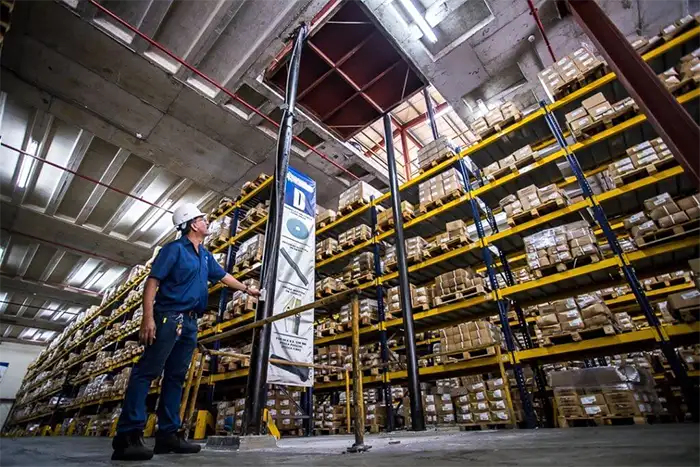 Trabajador supervisando el stock dentro de un almacén de productos